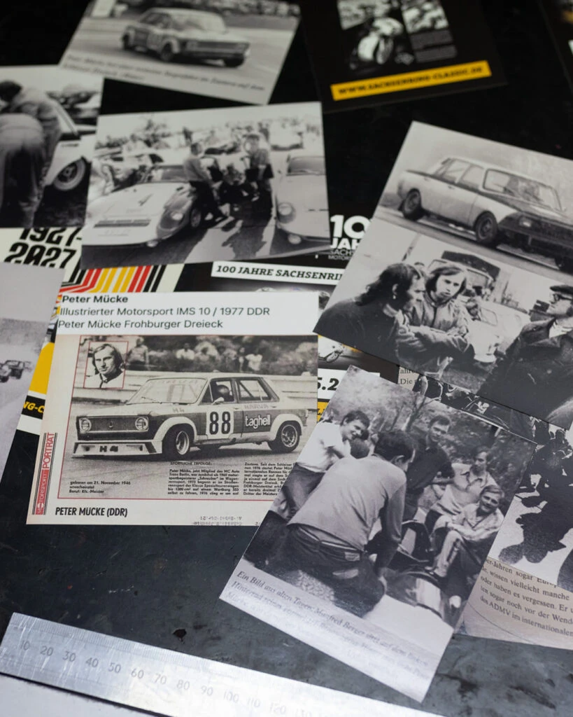 Nahaufnahme von historischen Zeitungsartikeln, Rennsport-Fotos und Berichten über Peter Mücke