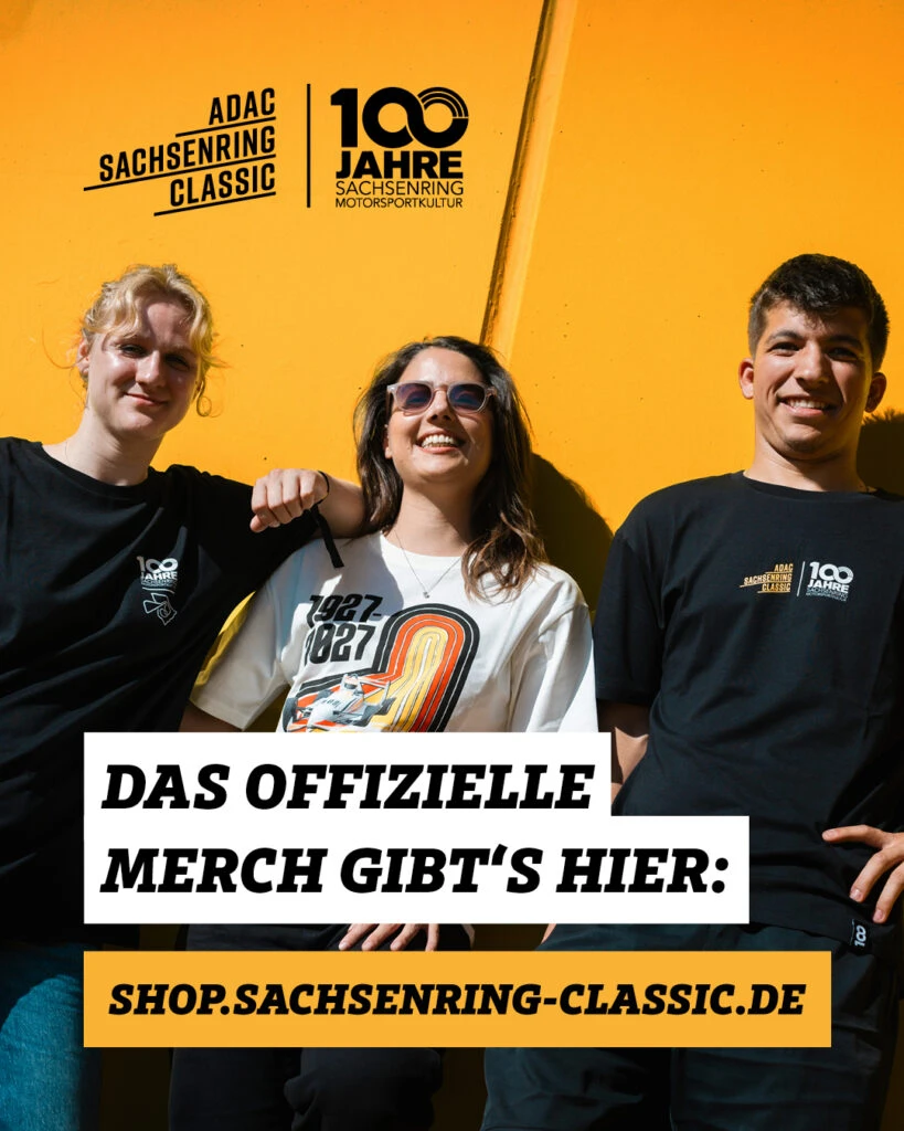 Drei junge Menschen tragen T-Shirts der offiziellen Jubiläumskollektion „100 Jahre Sachsenring Motorkultur“ vor einer gelben Wand mit der Aufschrift „Das offizielle Merch gibt's hier: shop.sachsenring-classic.de“.