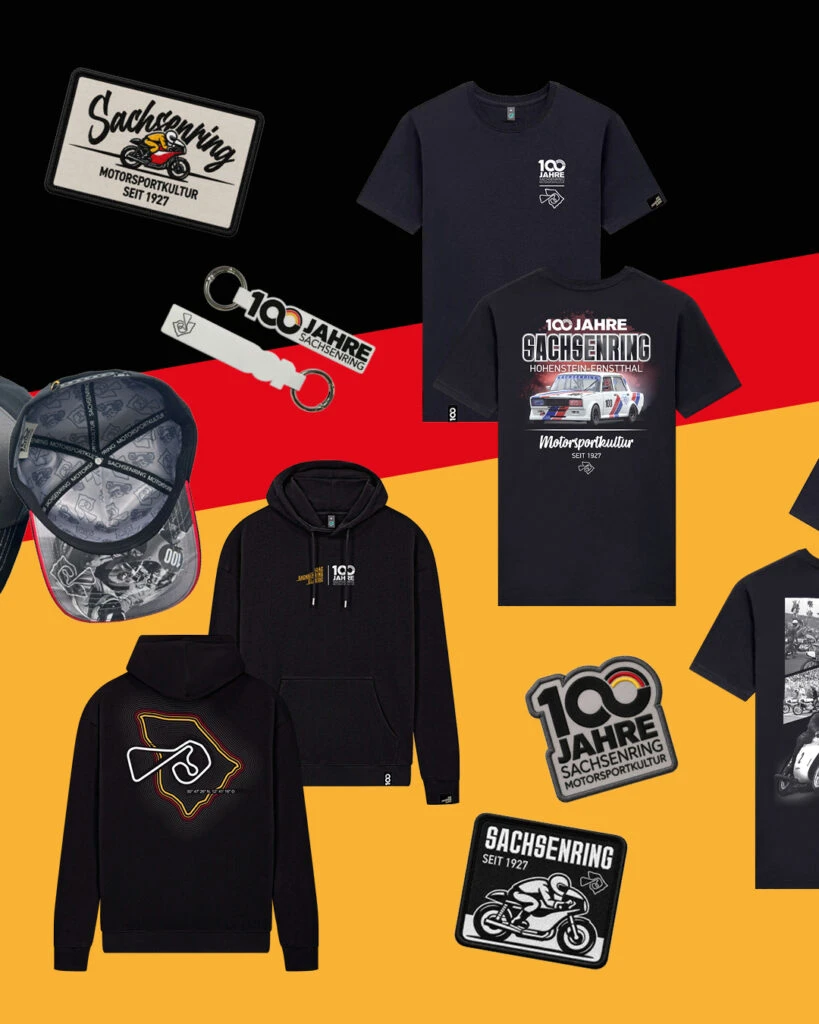 Schwarze Fanartikel zum Jubiläum 100 Jahre Sachsenring Motorkultur, inklusive Hoodies mit Rennstrecken-Silhouette, T-Shirts, Caps, Schlüsselanhängern und Patches.