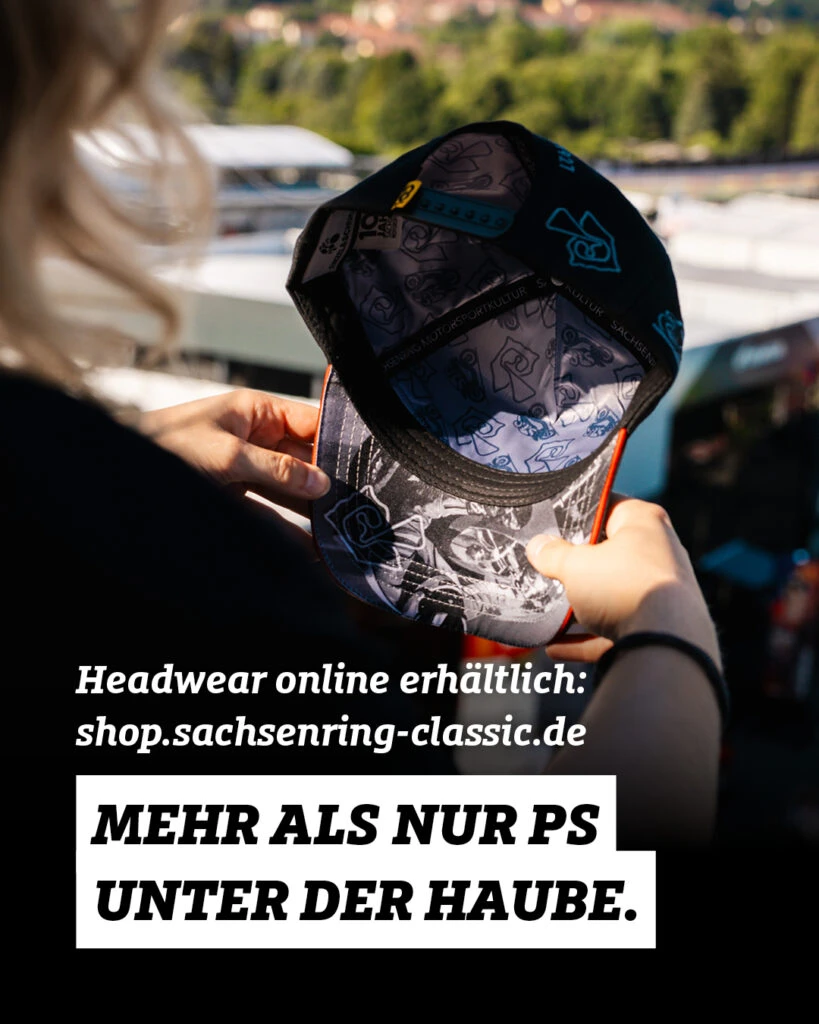Personenansicht der Innenseite einer schwarzen Sachsenring-Basecap mit aufwendigem Innenfutter-Print vor Motorsport-Kulisse.