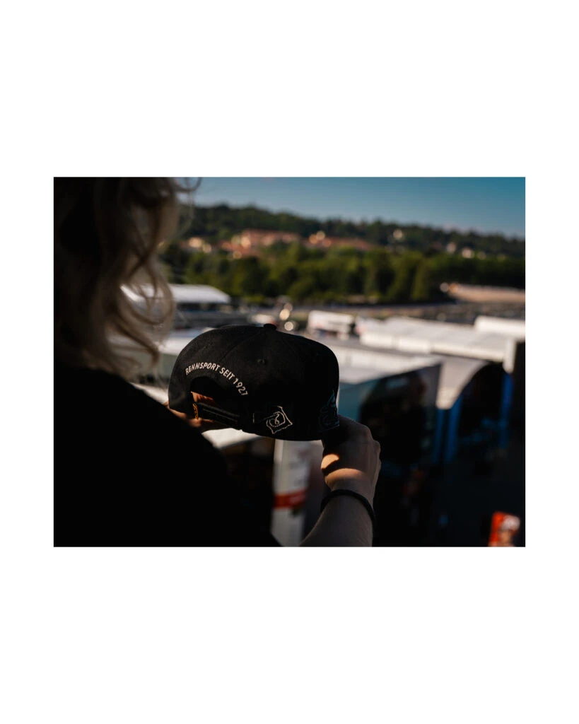 Rückansicht einer schwarzen Motorsport-Cap mit weißem Stickzug „Rennsport seit 1927“.